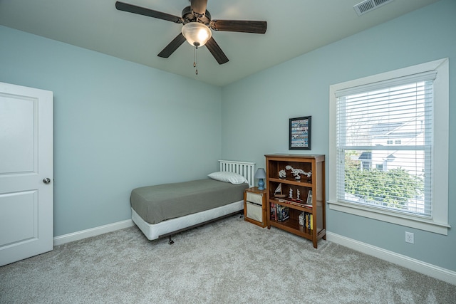 carpeted bedroom featuring baseboards, visible vents, and ceiling fan