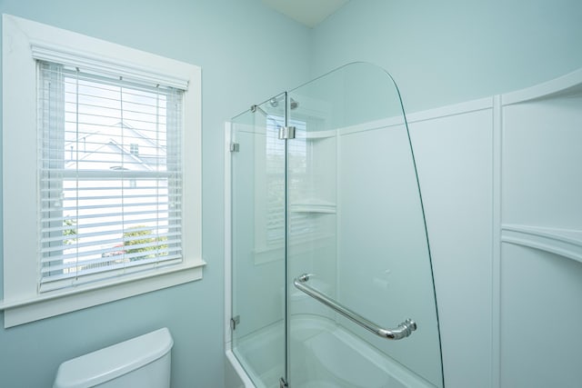 full bathroom featuring toilet and bath / shower combo with glass door