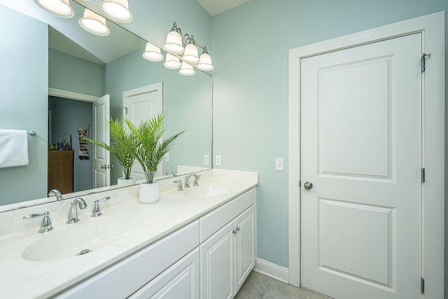 bathroom featuring double vanity, tile patterned flooring, baseboards, and a sink