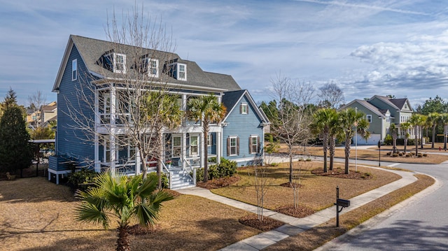 view of front facade featuring a shingled roof and driveway