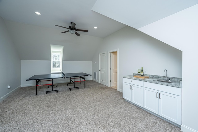 rec room featuring lofted ceiling, light carpet, a sink, ceiling fan, and baseboards