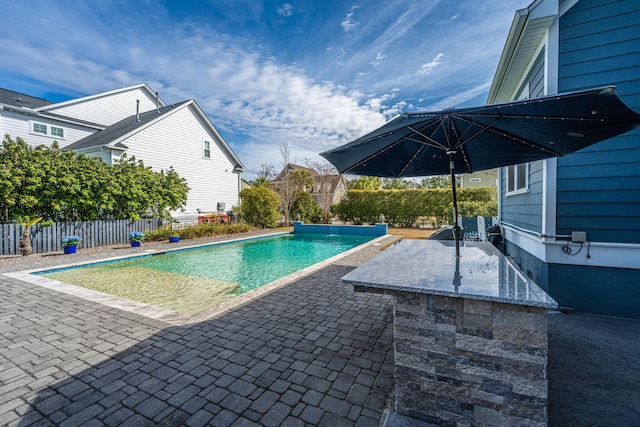 view of swimming pool with a patio, an outdoor kitchen, fence, and a fenced in pool