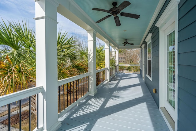 wooden terrace featuring covered porch and a ceiling fan