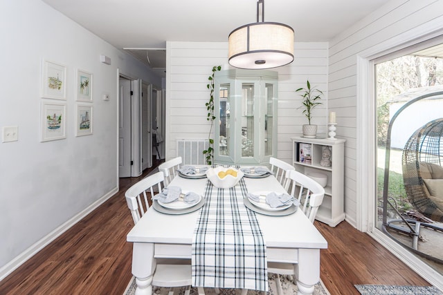 dining area featuring dark hardwood / wood-style floors and wood walls