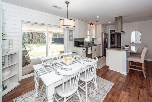 dining room featuring dark wood-type flooring and sink