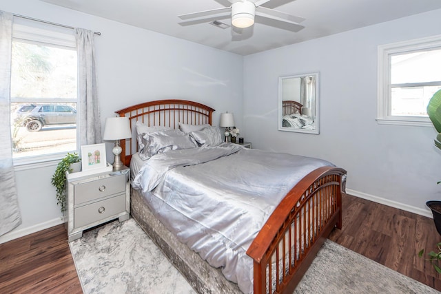 bedroom featuring ceiling fan, dark hardwood / wood-style floors, and multiple windows