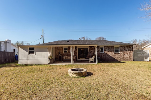 back of property featuring a yard and a fire pit