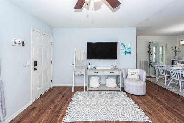 living room with ceiling fan and dark hardwood / wood-style flooring