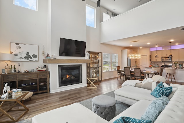 living room featuring a towering ceiling and dark hardwood / wood-style floors