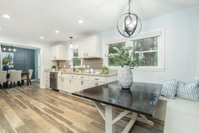 kitchen featuring pendant lighting, white cabinetry, light hardwood / wood-style flooring, and a chandelier