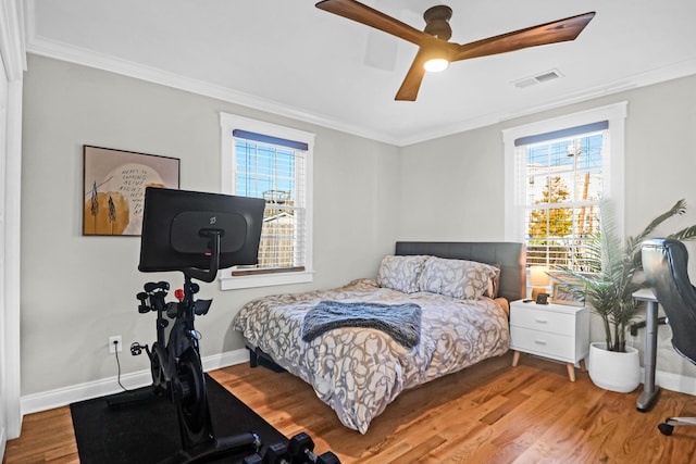 bedroom featuring ceiling fan, crown molding, and wood-type flooring