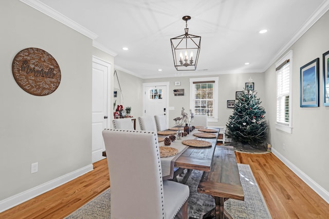 dining area featuring light hardwood / wood-style flooring, an inviting chandelier, and ornamental molding