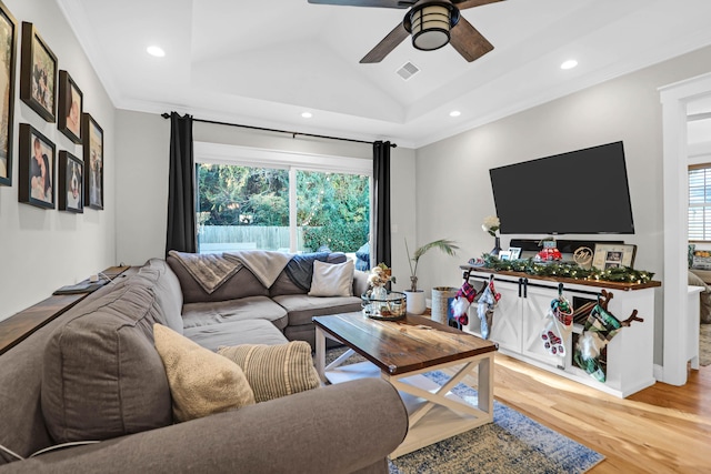 living room with ceiling fan, a healthy amount of sunlight, lofted ceiling, and hardwood / wood-style flooring