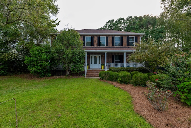 colonial inspired home featuring a front yard and covered porch