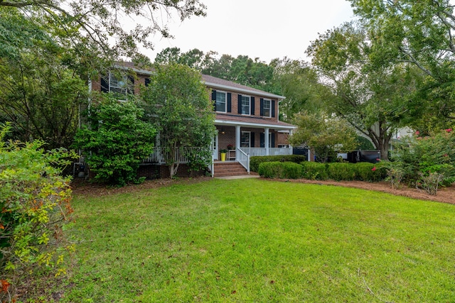 colonial inspired home with a front yard and covered porch