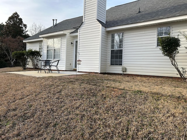 back of property with a patio and a yard