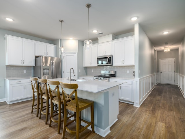 kitchen with visible vents, a sink, dark wood-style floors, stainless steel appliances, and light countertops