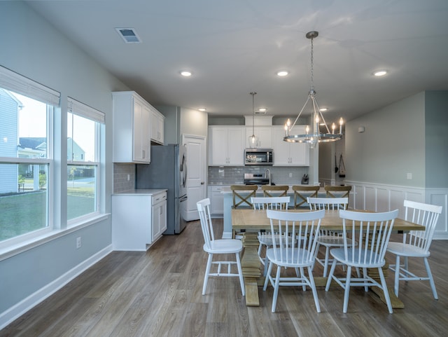 kitchen featuring white cabinetry, an inviting chandelier, stainless steel appliances, and hanging light fixtures