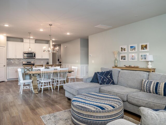 living room featuring a notable chandelier and light wood-type flooring