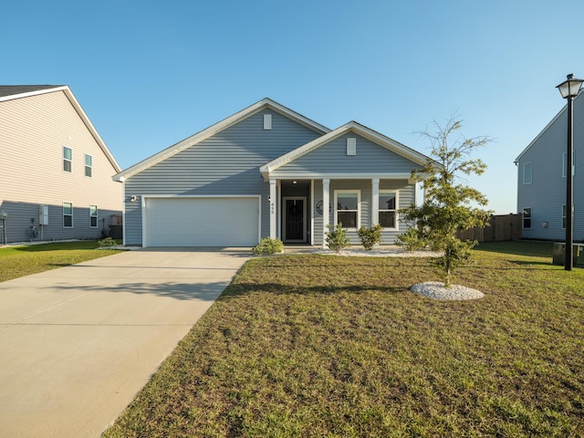 view of front facade featuring concrete driveway, fence, a garage, and a front yard