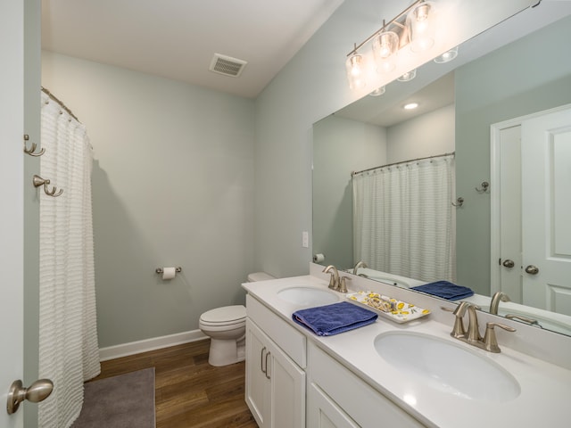 bathroom with vanity, toilet, curtained shower, and wood-type flooring