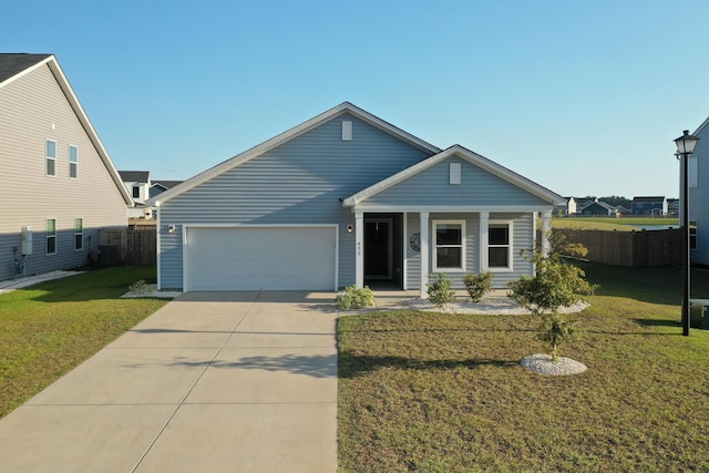 view of front of property with a garage, driveway, a front yard, and fence