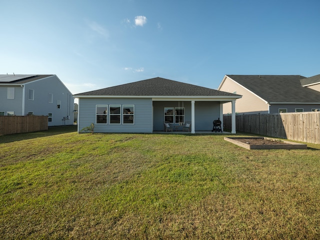 rear view of house featuring a lawn and a patio