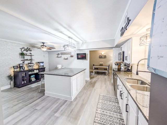 kitchen with sink, appliances with stainless steel finishes, ceiling fan, and white cabinetry