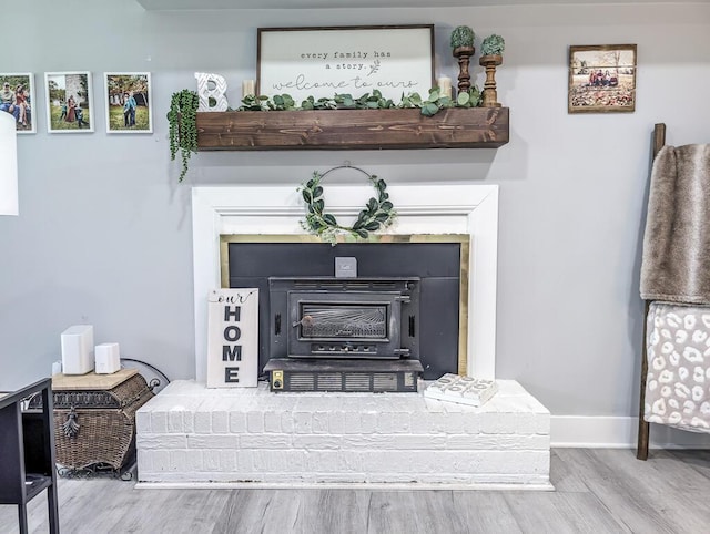 interior details with wood-type flooring and a wood stove