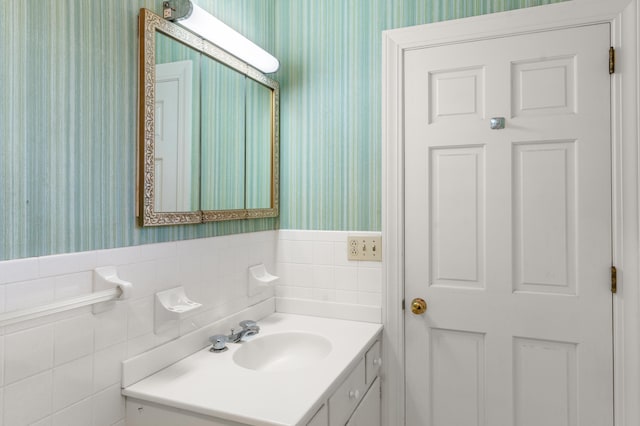 bathroom with vanity and wallpapered walls