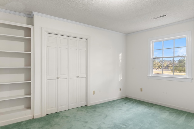 unfurnished bedroom featuring baseboards, ornamental molding, carpet floors, and a textured ceiling