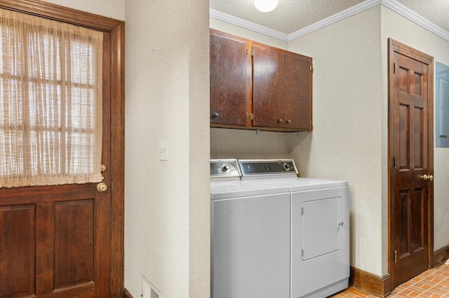 clothes washing area featuring brick floor, cabinet space, ornamental molding, baseboards, and washer and clothes dryer