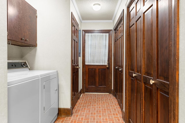 laundry area with brick floor, cabinet space, a textured ceiling, washer and clothes dryer, and crown molding