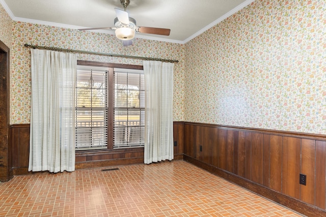 unfurnished room with wallpapered walls, ornamental molding, and wainscoting