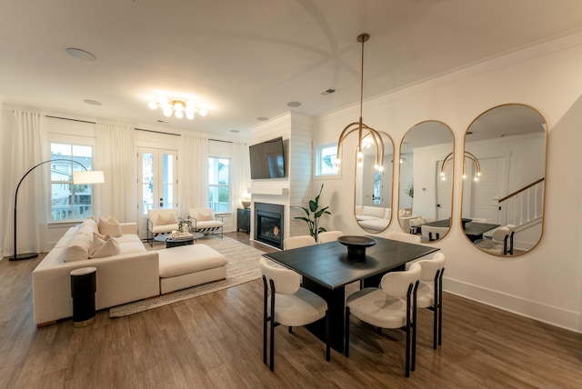 dining space featuring crown molding, wood-type flooring, and french doors