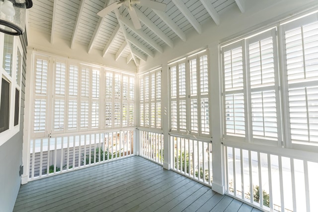 unfurnished sunroom with ceiling fan and vaulted ceiling with beams