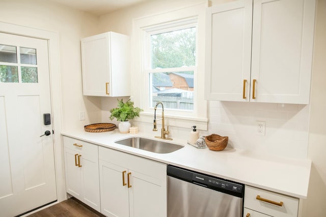 kitchen with dishwasher, white cabinets, tasteful backsplash, and sink