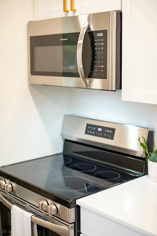 interior details featuring white cabinets and appliances with stainless steel finishes