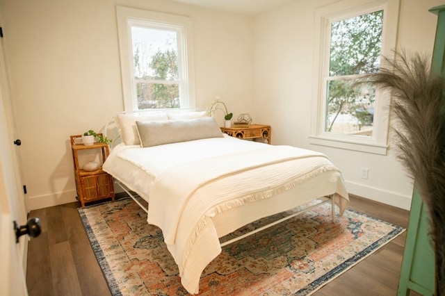 bedroom with dark hardwood / wood-style flooring and multiple windows