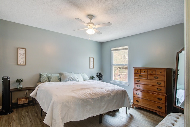 bedroom featuring ceiling fan, a textured ceiling, and wood finished floors