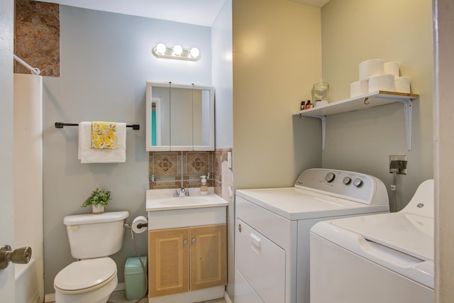 clothes washing area featuring a sink, laundry area, and washer and dryer