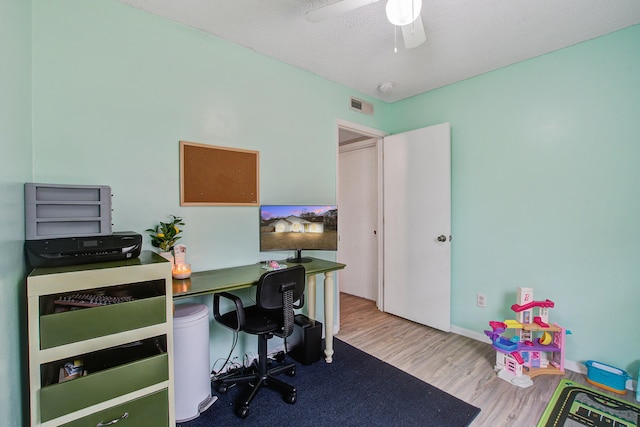 office with a ceiling fan, visible vents, and wood finished floors