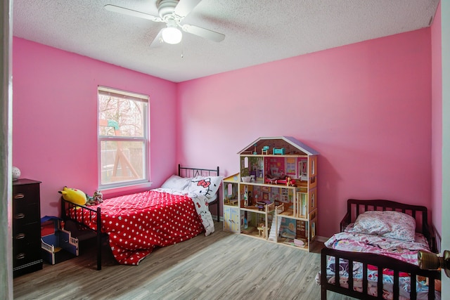 bedroom with a textured ceiling, wood finished floors, and a ceiling fan