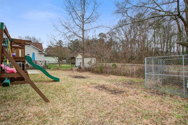 view of yard with fence, a playground, and an outbuilding