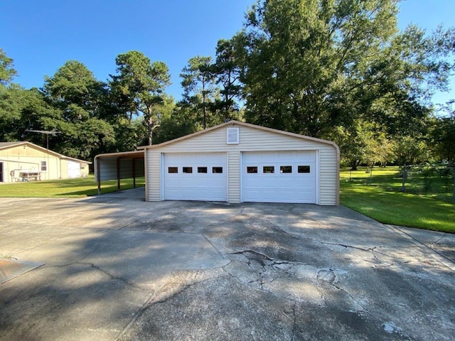 garage with a carport and a lawn