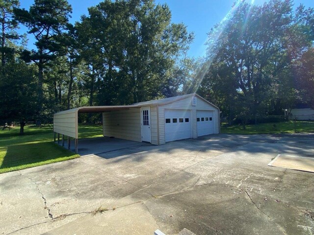 garage featuring a carport and a yard