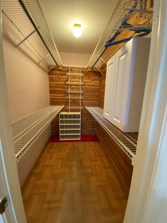 spacious closet featuring parquet floors