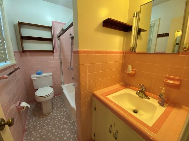 full bathroom with tile patterned floors, toilet, tub / shower combination, tile walls, and vanity