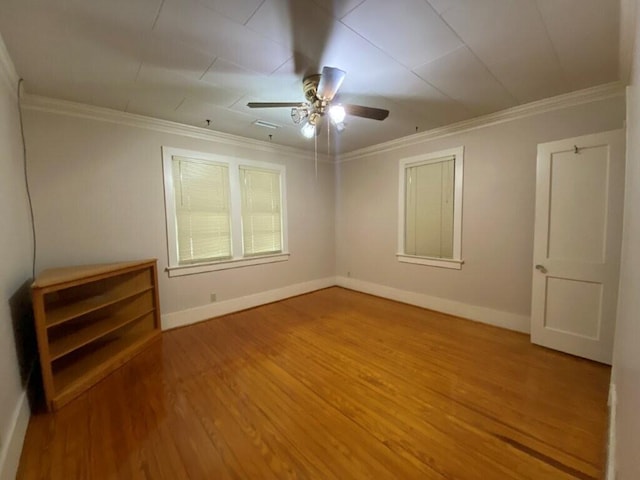 spare room featuring crown molding, wood-type flooring, and ceiling fan