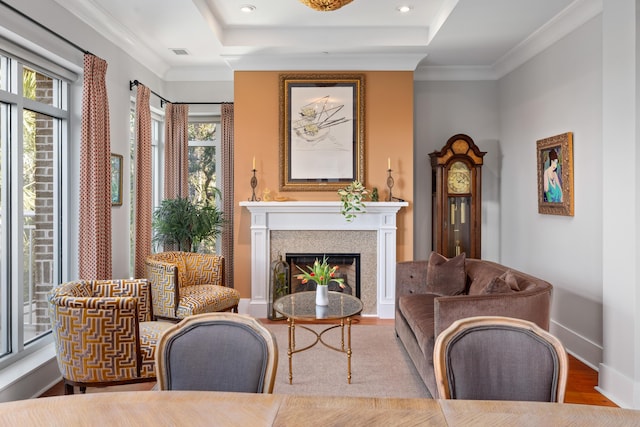 living area with crown molding, plenty of natural light, and light wood-type flooring